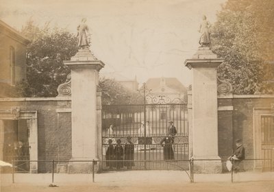 Kinder stehen und schauen durch das Schultor von English Photographer